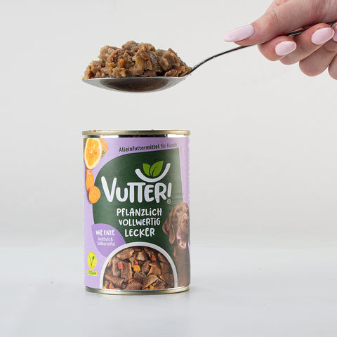 Ein Esslöffel des veganen Nassfutters wie Ente von Vutter! wird aus der Dose genommen.