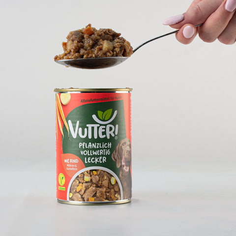 Ein Esslöffel unseres veganen Nassfutters wie Rind von Vutter! wird aus der Dose genommen