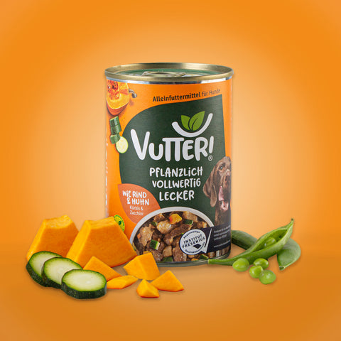 Neben einer Dose veganes Nassfutter wie Rind & Huhn von Vutter! liegen Kürbis und Zucchini sowie Sojabohnen.