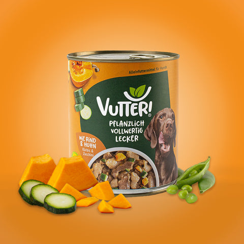Neben einer 800g Dose veganes Nassfutter wie Rind & Huhn von Vutter! liegen Kürbis und Zucchini sowie Sojabohnen.