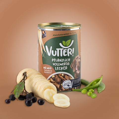 Neben einer Dose veganes Nassfutter wie Wild von Vutter! liegen Pastinaken und Aroniabeeren sowie Sojabohnen.