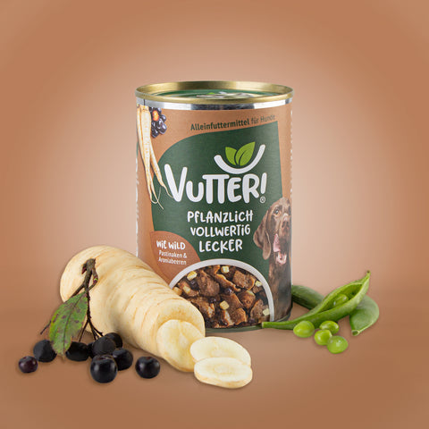 Neben einer Dose veganes Nassfutter wie Wild von Vutter! liegen Pastinaken und Aroniabeeren sowie Sojabohnen.