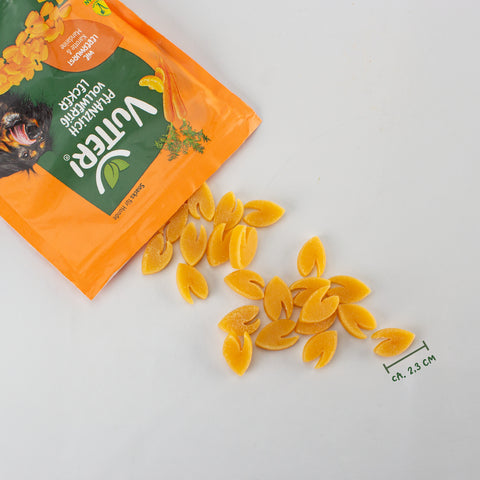 Aus einer offenen Tüte veganer Leckerli für Hunde wie Leberwurst von Vutter! sind ein paar Snacks herausgefallen